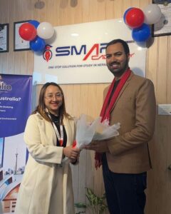 Woman presenting flower to man in Smart Academy setting.